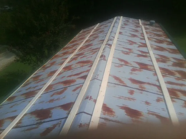 Rusted metal roof panels with new wood purlins before replacement — Storm Damage Roof Repair in Jesup by Roofing Brothers