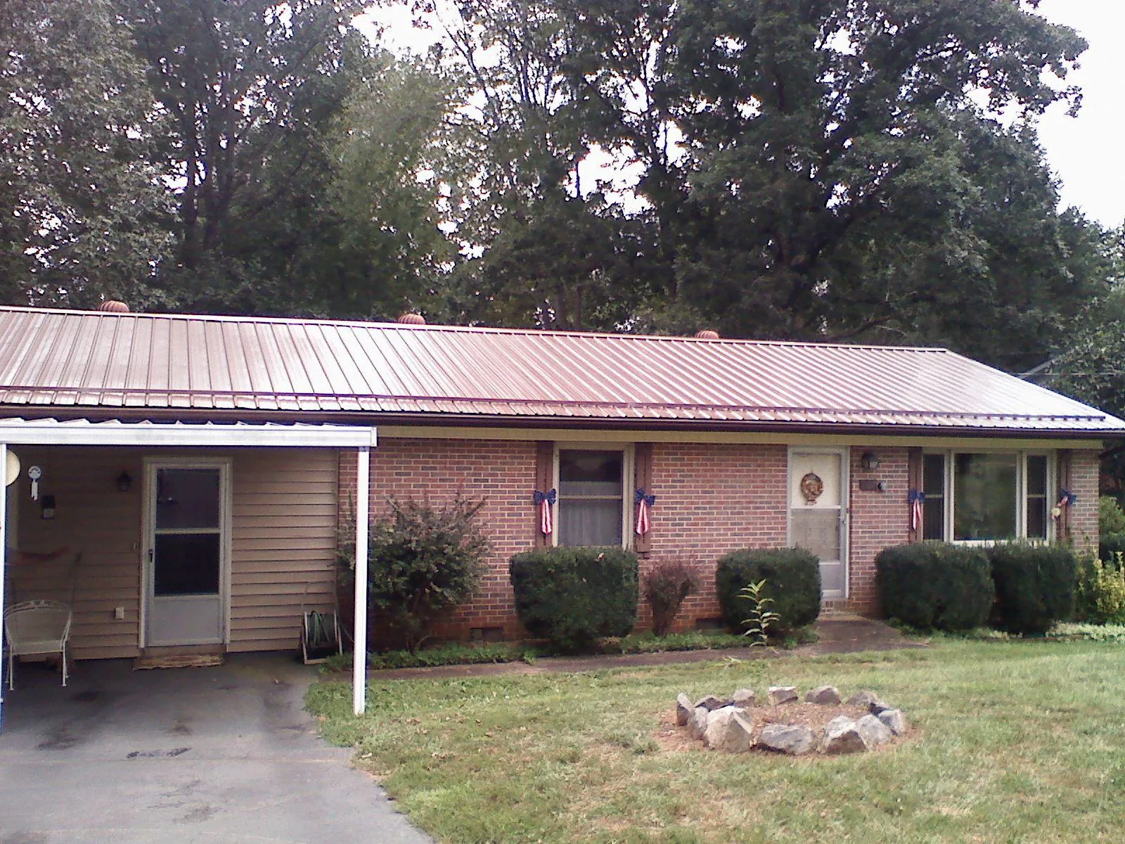 Bronze metal roof and carport on a brick ranch home — Roof Repair work by our crew in Jesup