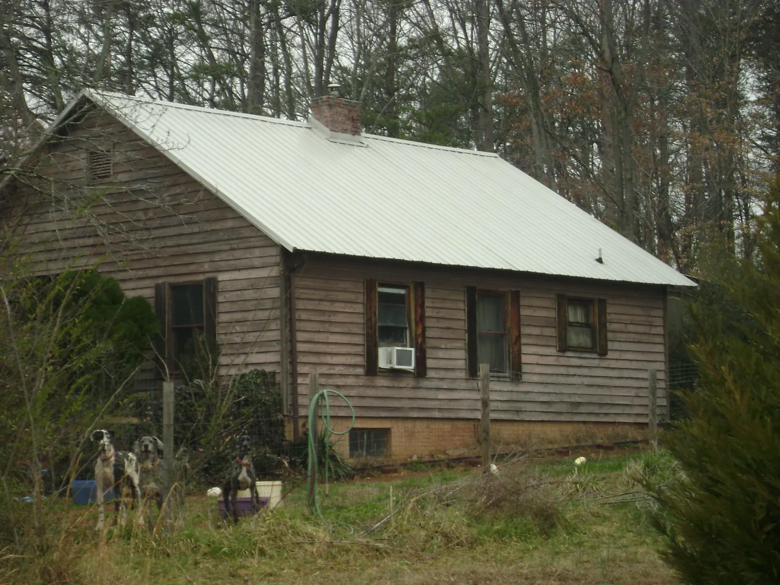 White metal roof on an old wood sided farmhouse, from a Metal Roof Installation job in Jesup